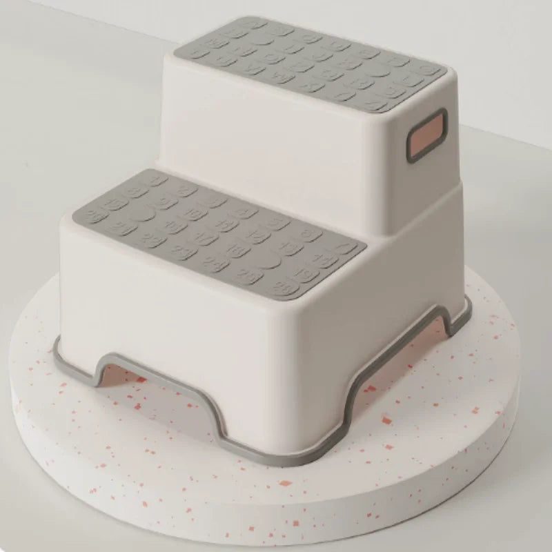 Gray and white 2-tier step stool for kids showing textured slip-resistant steps and safety rubber feet.